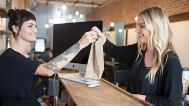 An employee checking a client out at a salon.