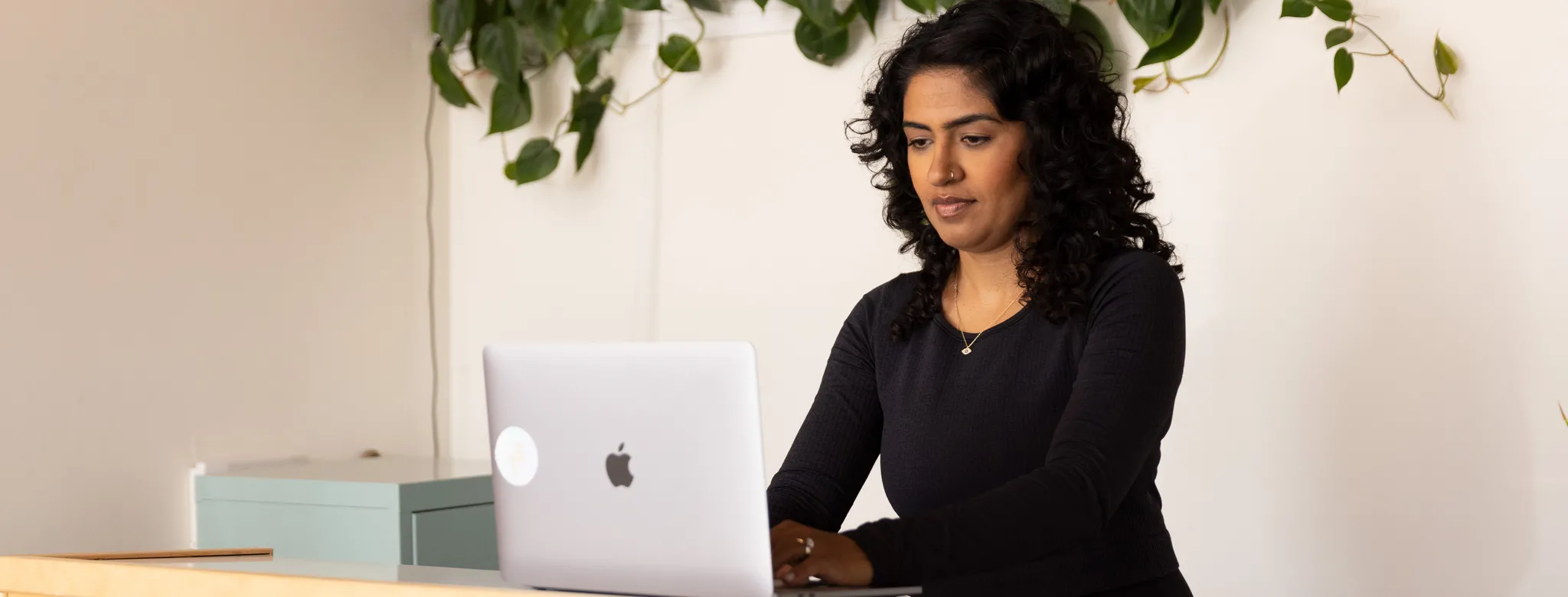 woman standing at desk using laptop