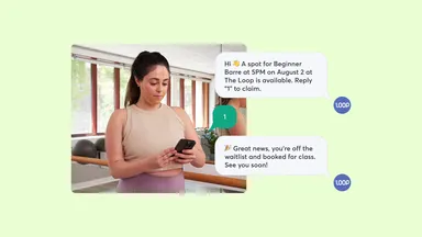 Woman in fitness class looking on phone for waitlist position