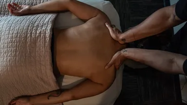 person on massage table getting massage from masseuse