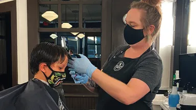 child getting hair cut in salon